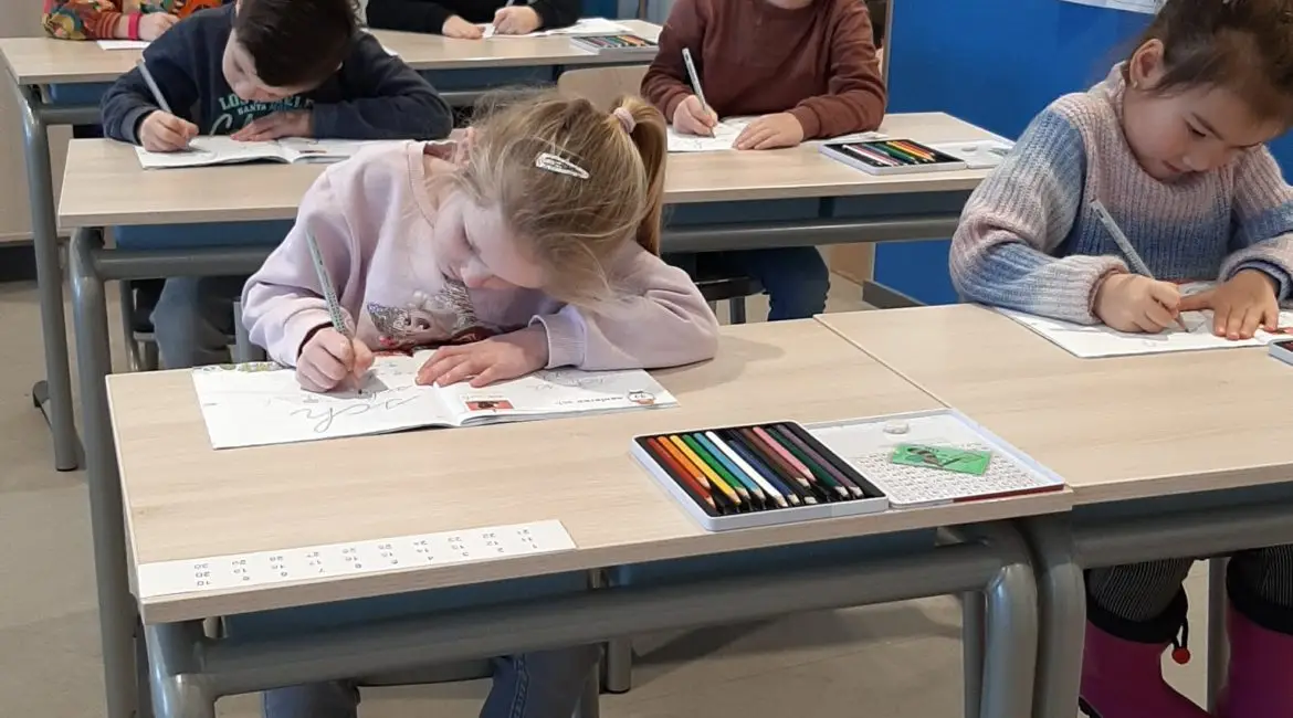 Meerdere kinderen oefenen met het schrijven.