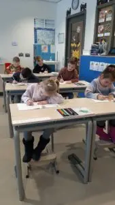 Meerdere kinderen oefenen met het schrijven.